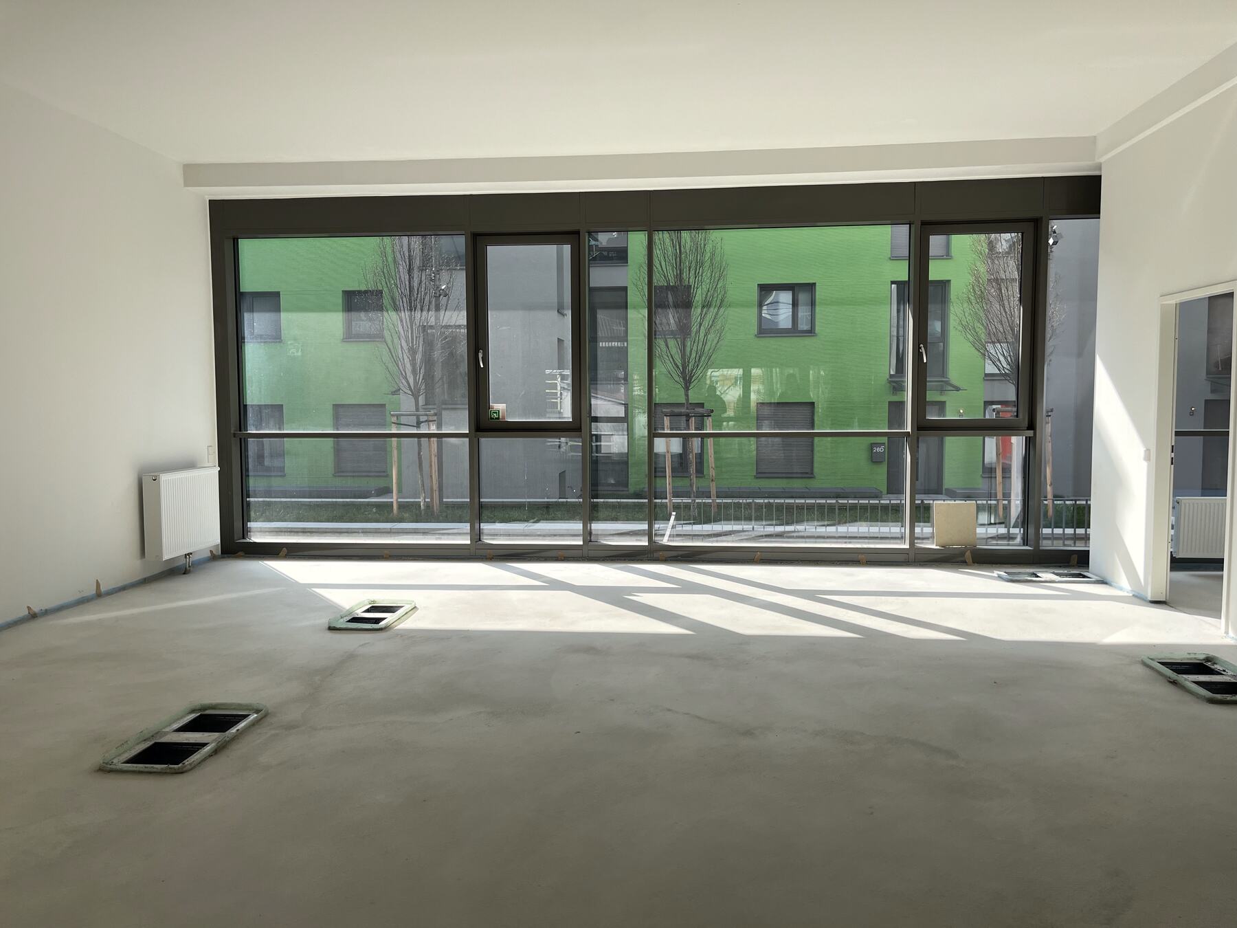 Heller, leerer Wohnraum mit großer Fensterfront
