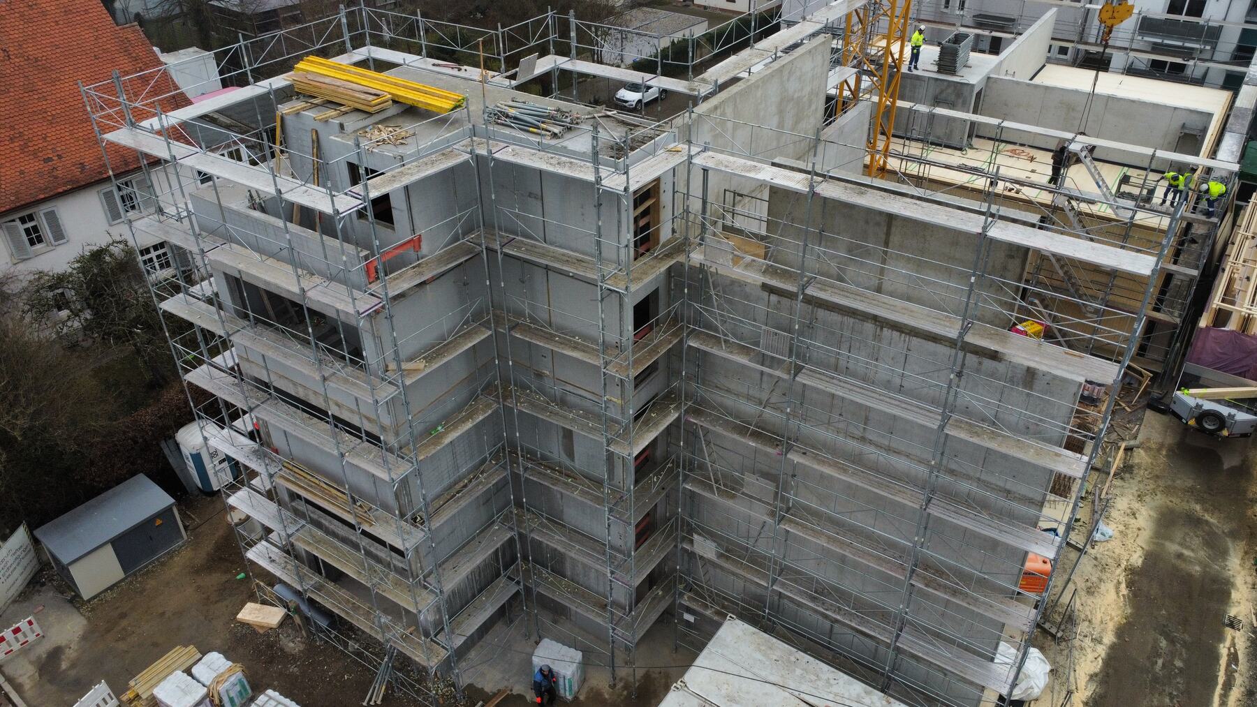 Rohbau eines Mehrfamilienhauses mit Gerüst aus der Luft